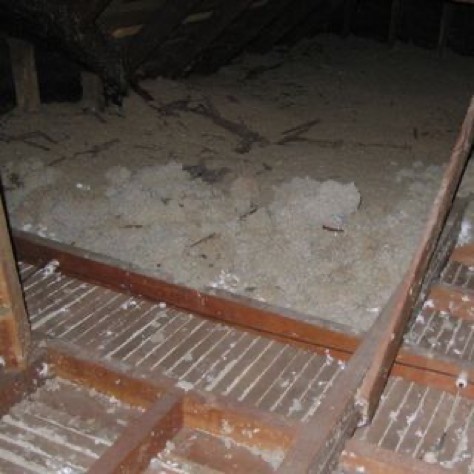 Attic filled with old, dirty and settled insulation before removal