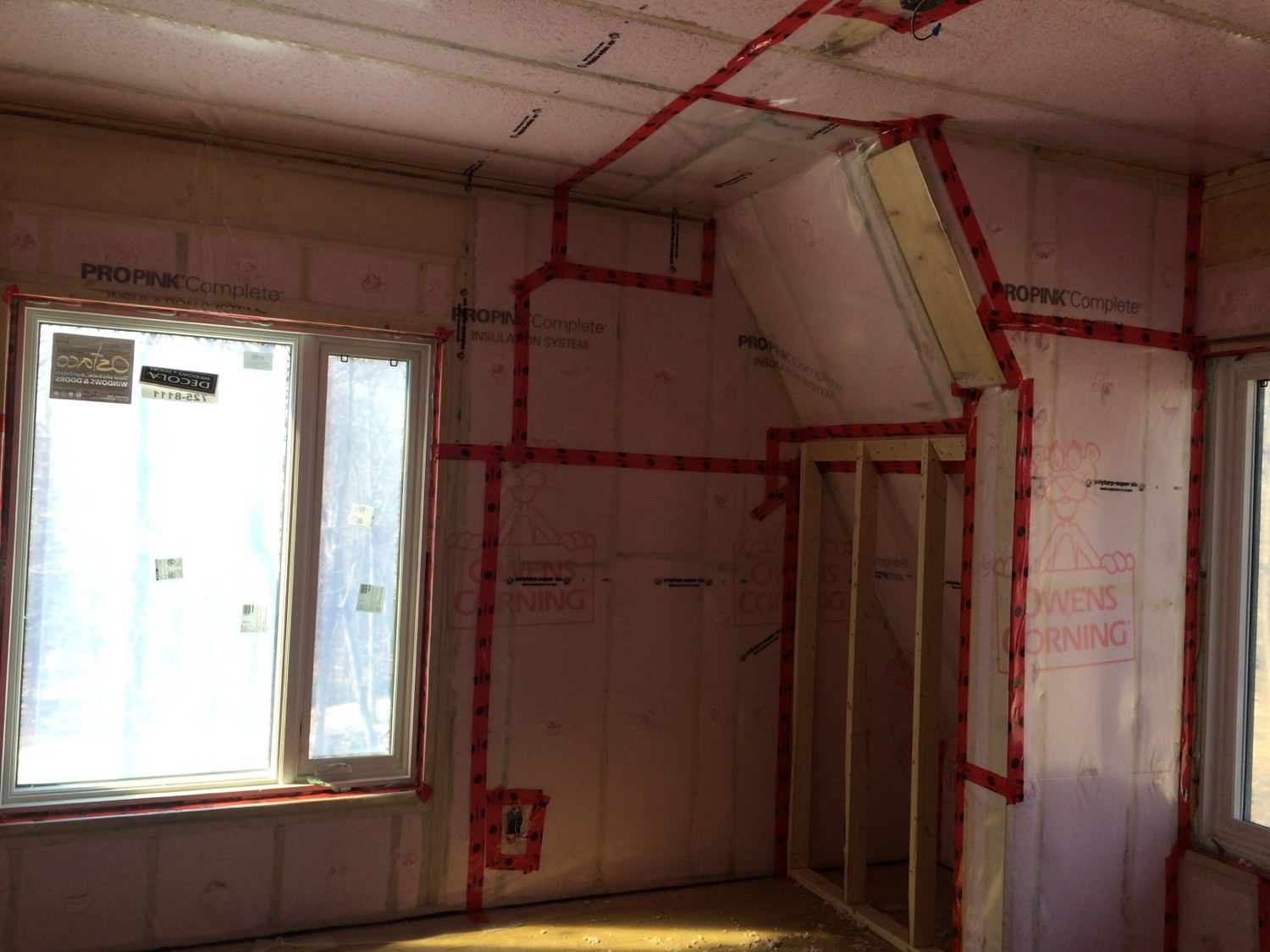 Wall cavities filled with BIBS blown-in insulation behind netting, ready for drywall