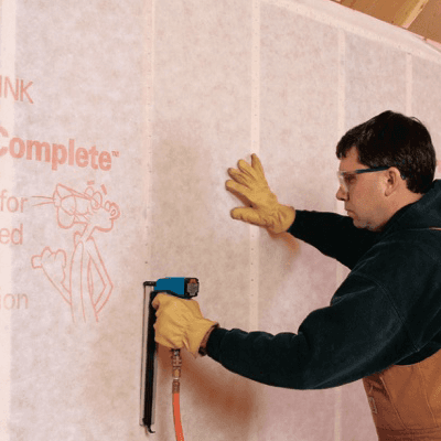 Installer drilling a small access hole into a finished interior wall