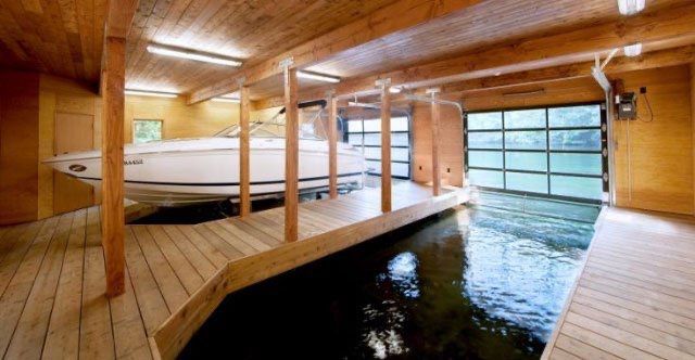 Interior of a boat house with a boat slip, insulated and finished in wood