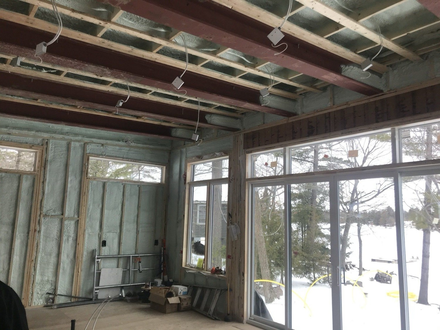 Closed-cell spray foam applied across the ceiling and walls of a cottage interior